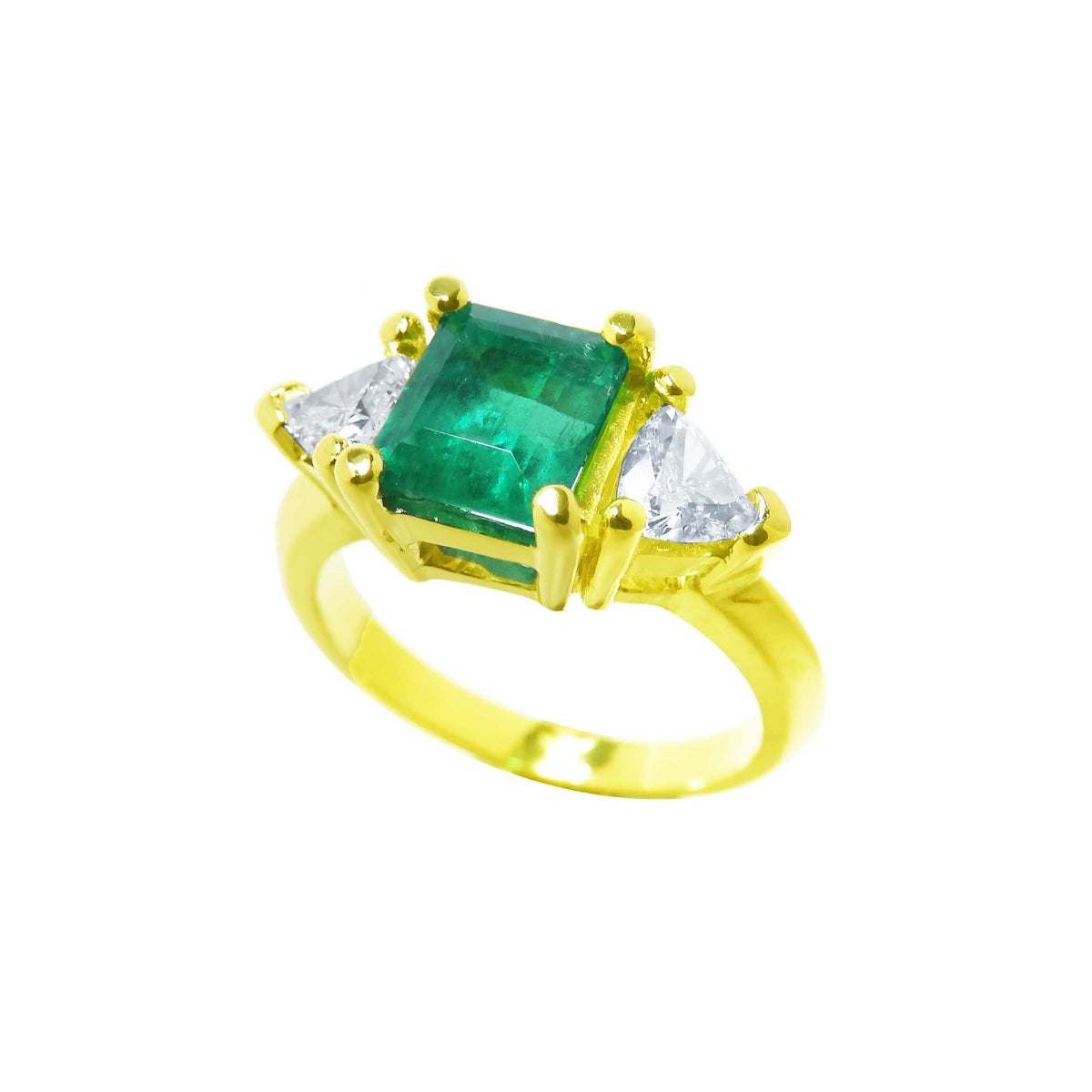A women's colombian emerald ring with side trillion cut diamonds in 18k yellow gold.