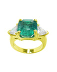 A GIA-certified natural Muzo Colombian emerald ring, featuring trillion-cut side diamonds and crafted in 18k gold.