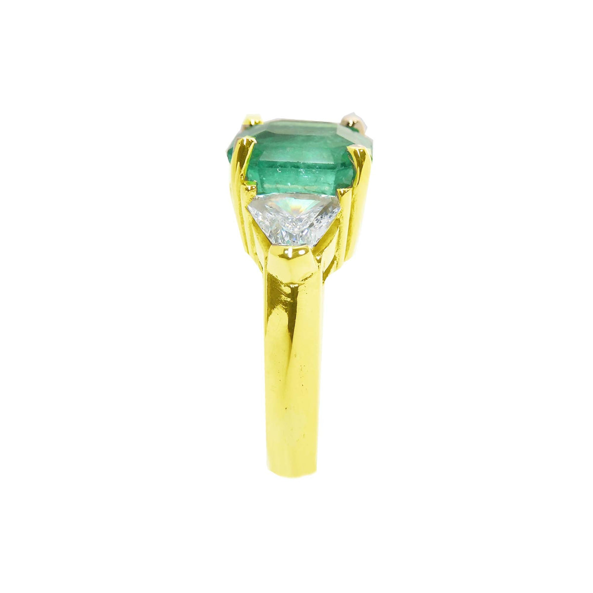 In a tilted position this emerald-cut emerald ring for women displays its side profile.