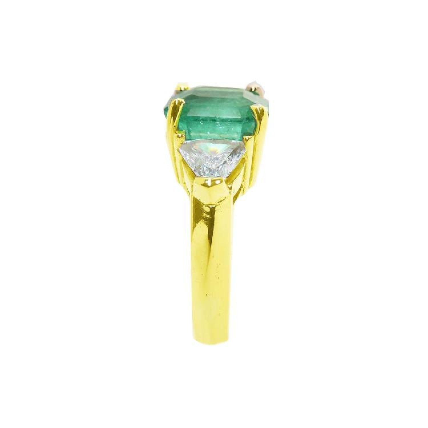 18k yellow gold ring with a large natural colombian emerald and two trillion side diamonds.