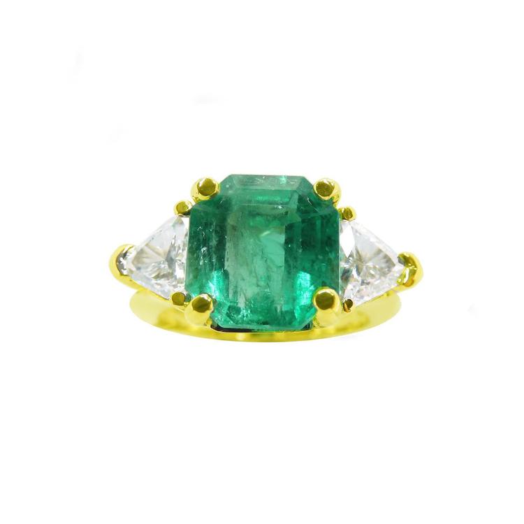 GIA certified three stone emerald and trillion cut side diamond ring, front position top view.
