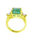 A 18k gold emerald and trillion cut diamond ring, top and gallery profile displayed.