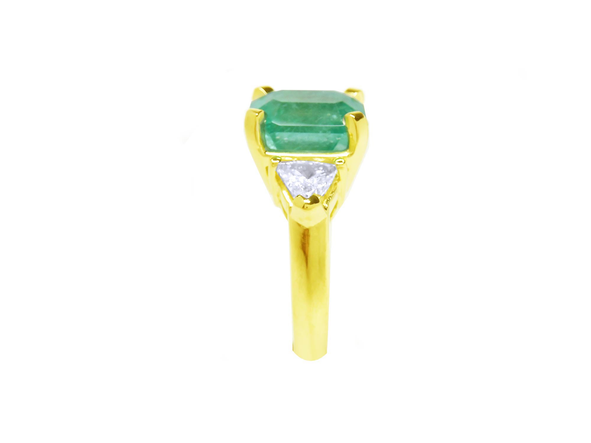 A side profile of a yellow gold emerald ring.