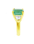 A side profile of a yellow gold emerald ring.