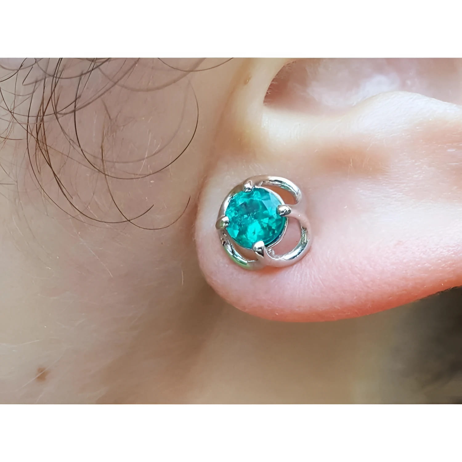 A tulip natural colombian emerald stud earring in 14k white gold on an ear.