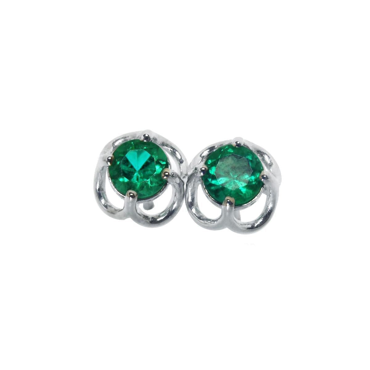 Pair of emerald tulip emerald stud earrings on a front position top view
