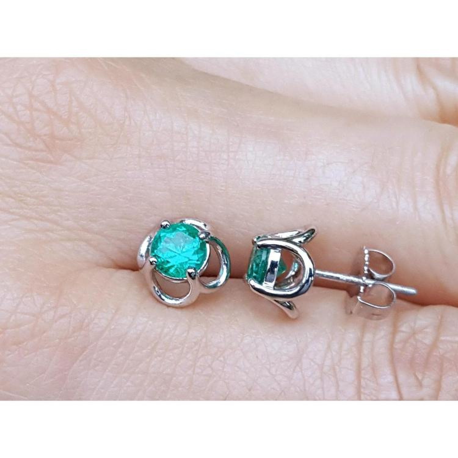 Tulip emerald stud earrings with round cut green emeralds set in 14K white gold.