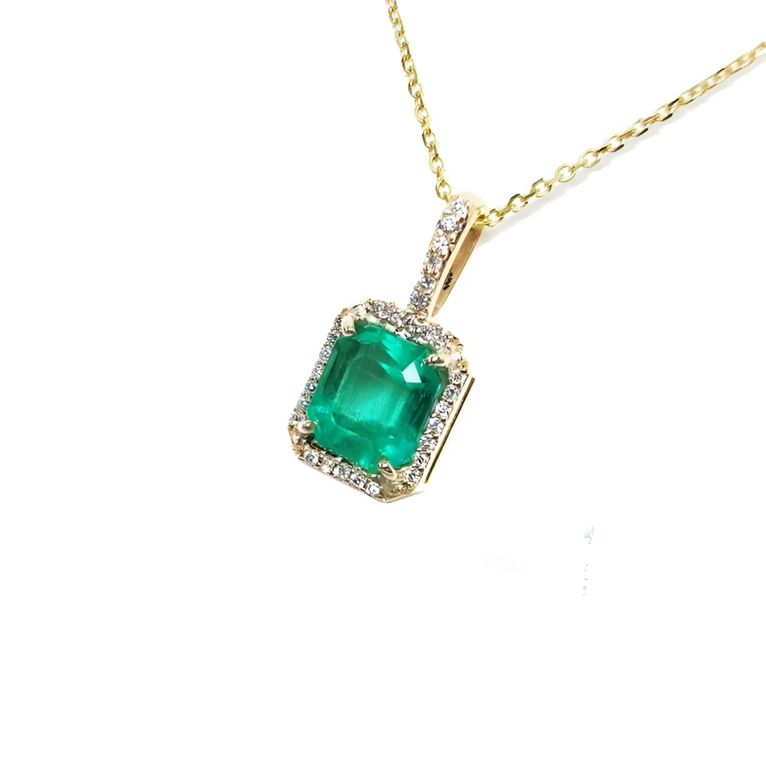Emerald-cut emerald pendant with diamond halo on a 14k yellow gold chain.