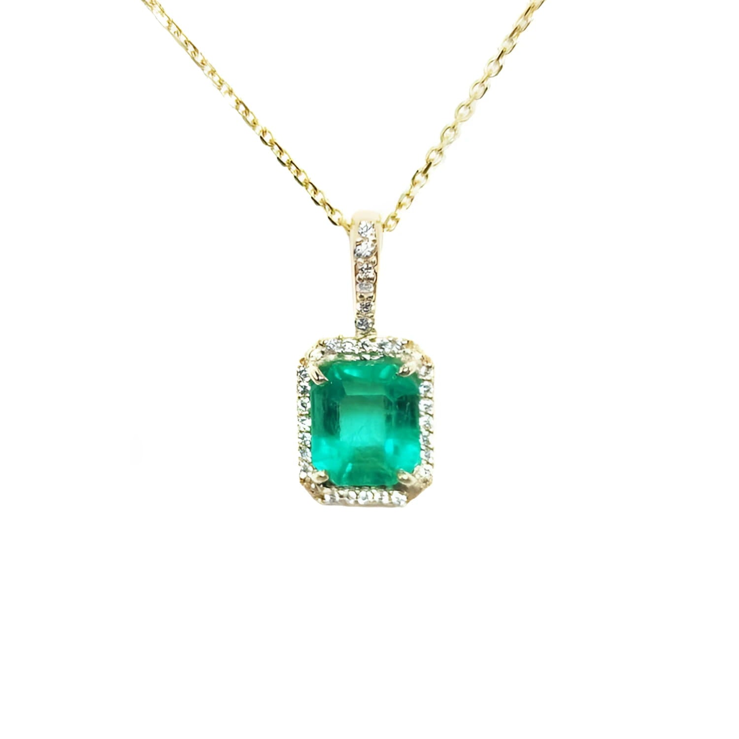 Emerald-cut emerald pendant with diamond halo on a 14k yellow gold chain.