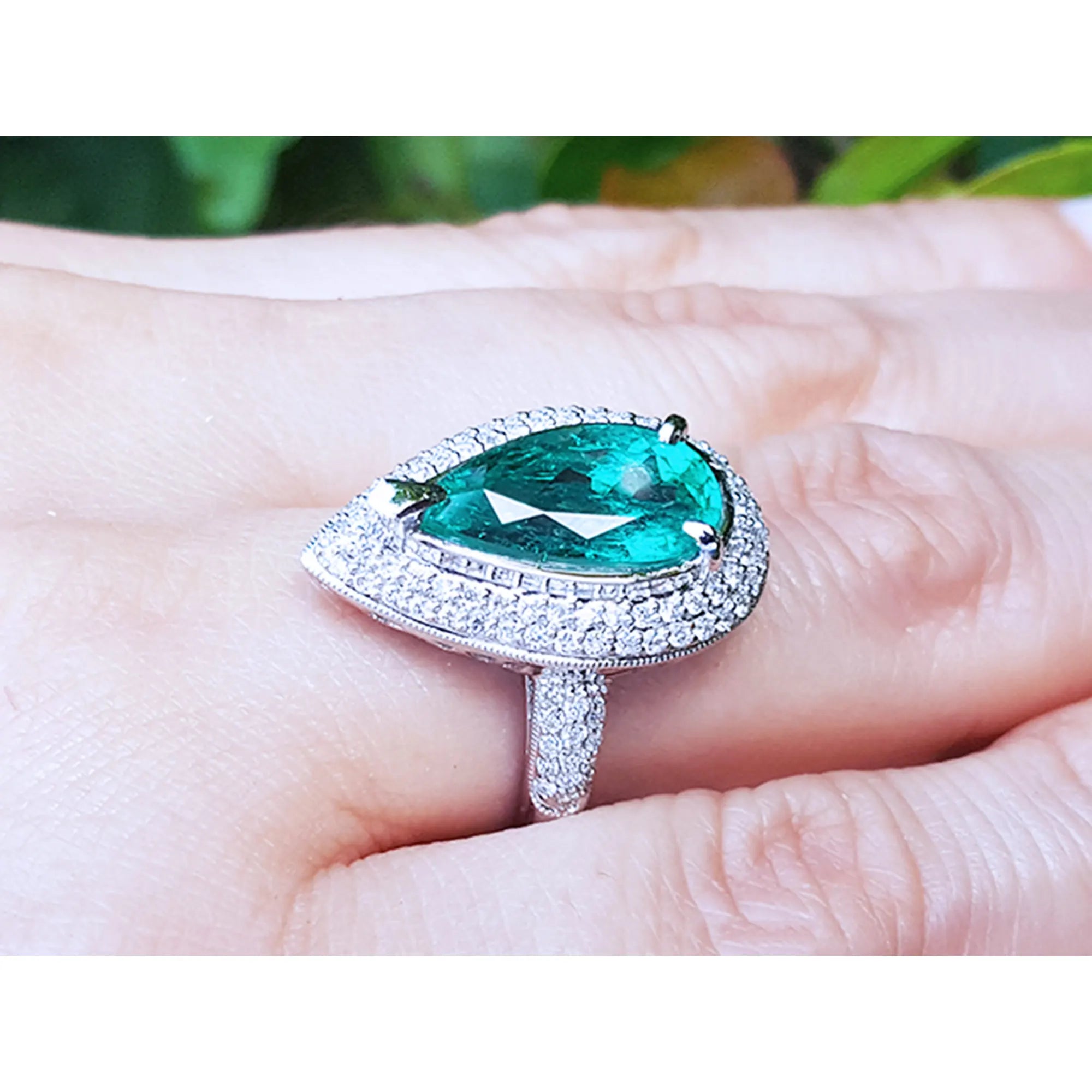 Anillo con esmeralda en mano de mujer mostrando su posición en el dedo. 