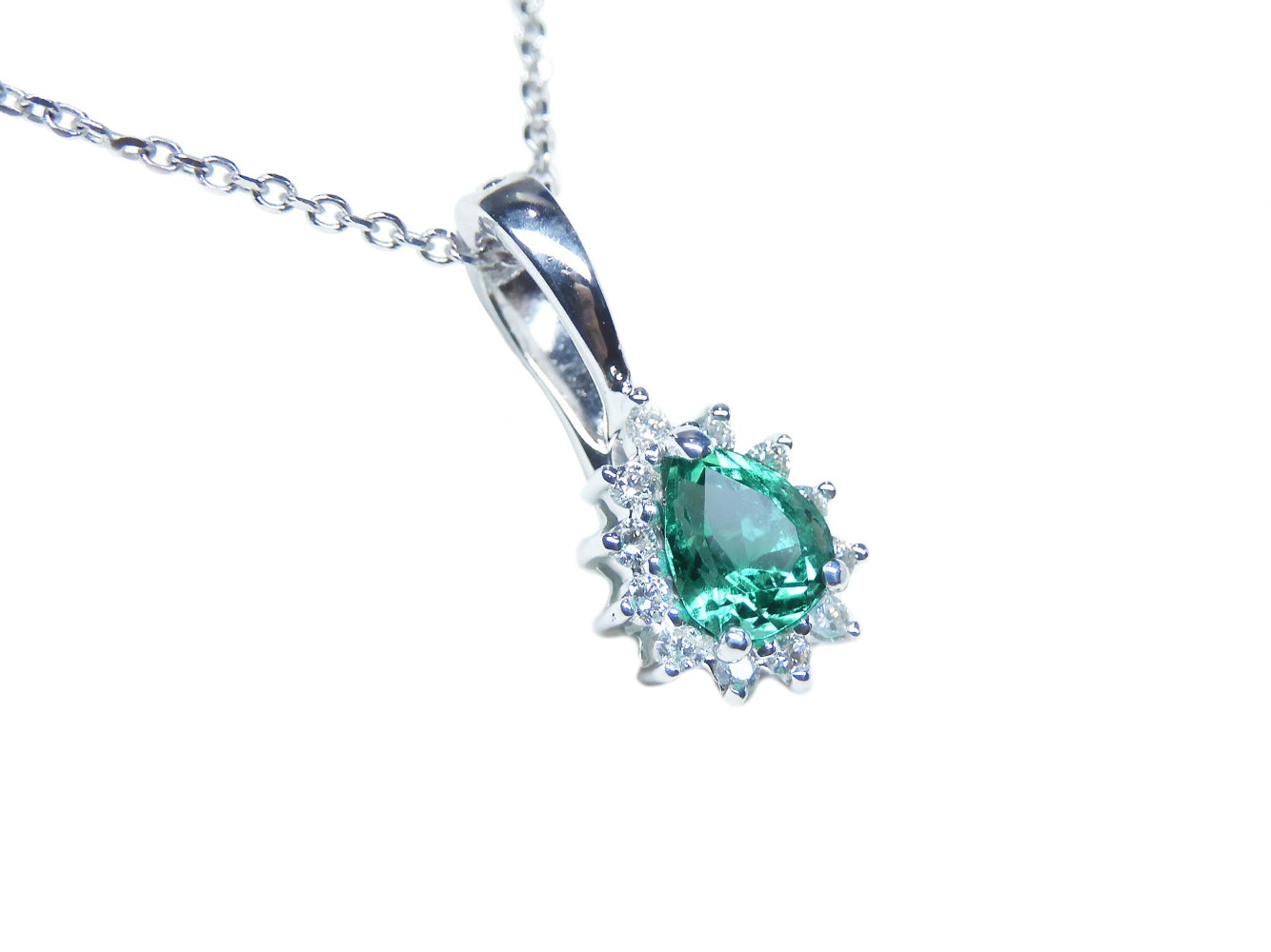White gold enhancer pendant with a natural emerald gemstone on a right topside position.