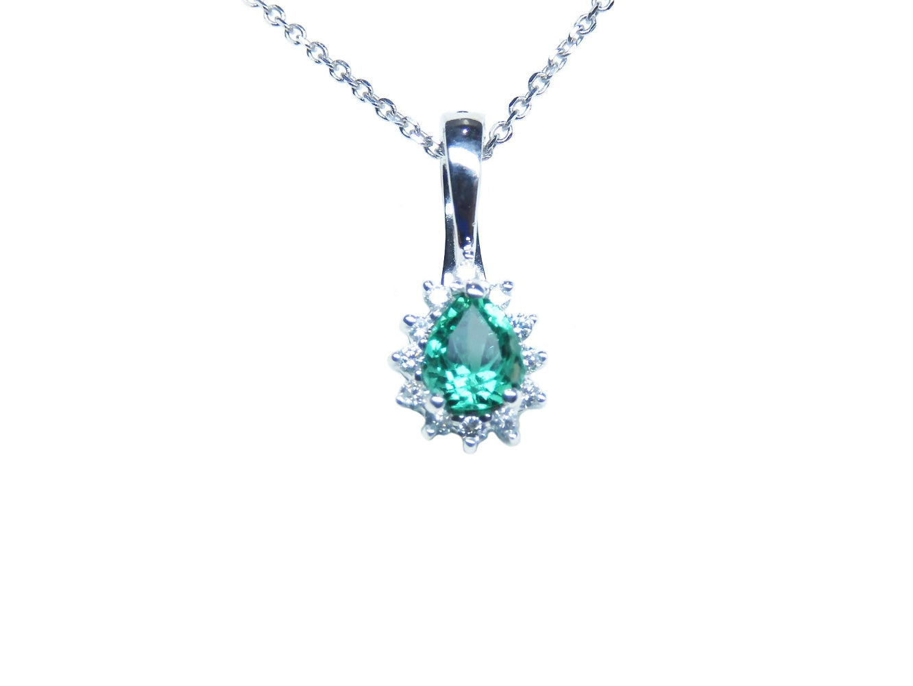 A pear shaped emerald enhancer pendant necklace displaying its topside view.