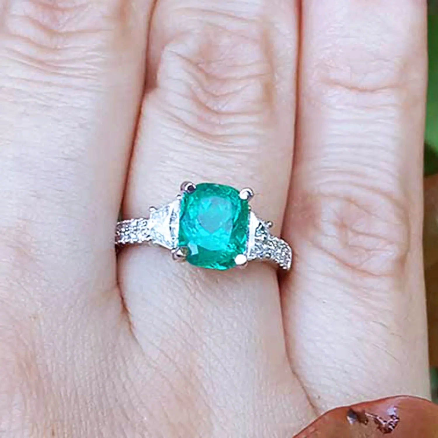 Esmeralda Colombiana y diamantes trapezoides laterales en anillo para mujer.