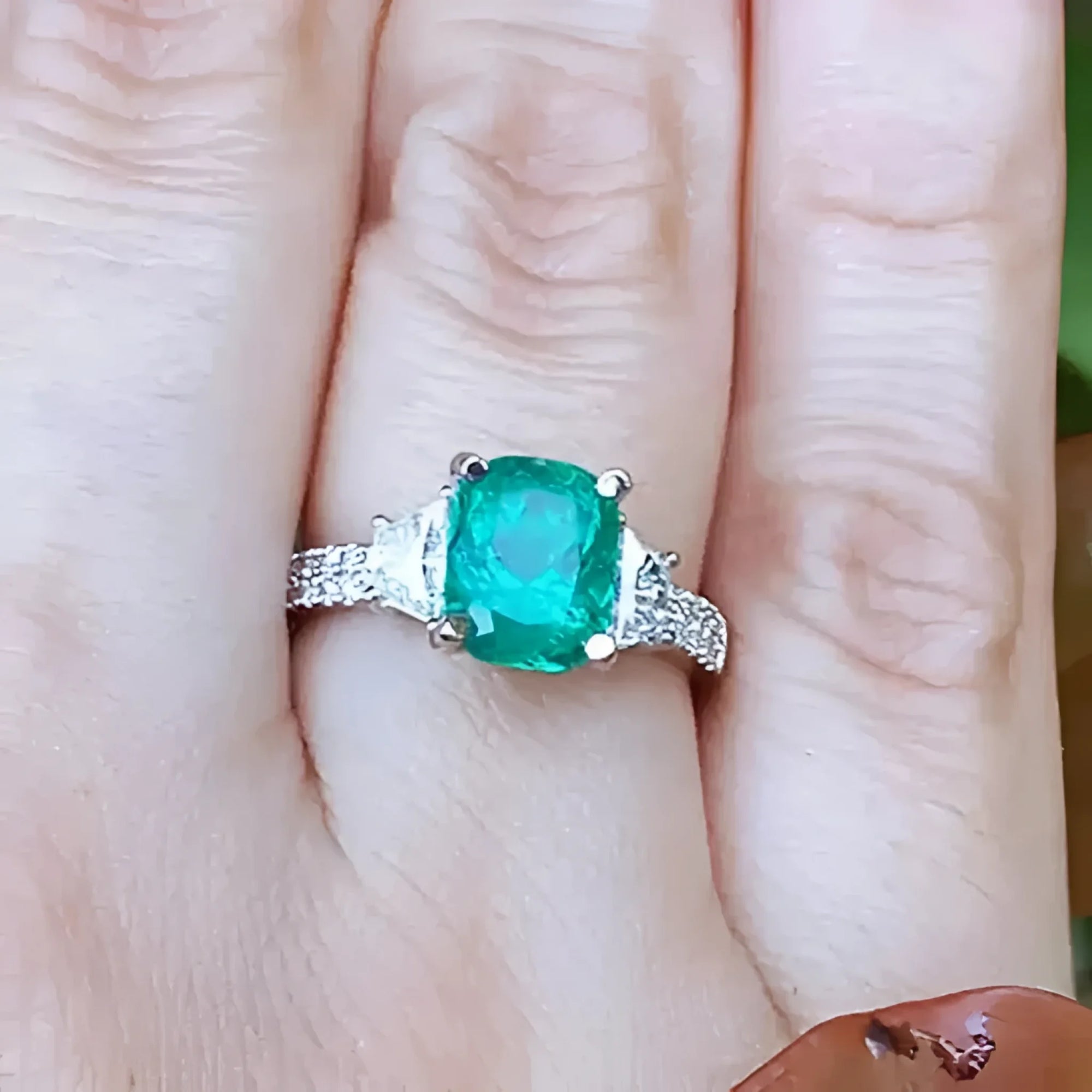 Esmeralda Colombiana y diamantes trapezoides laterales en anillo para mujer.