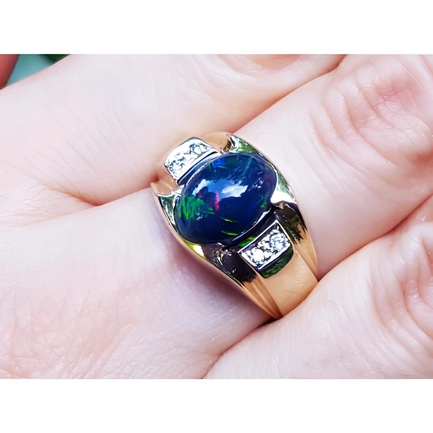 Men's 14K yellow gold ring with a dark Ethiopian black opal and small white accent stones.