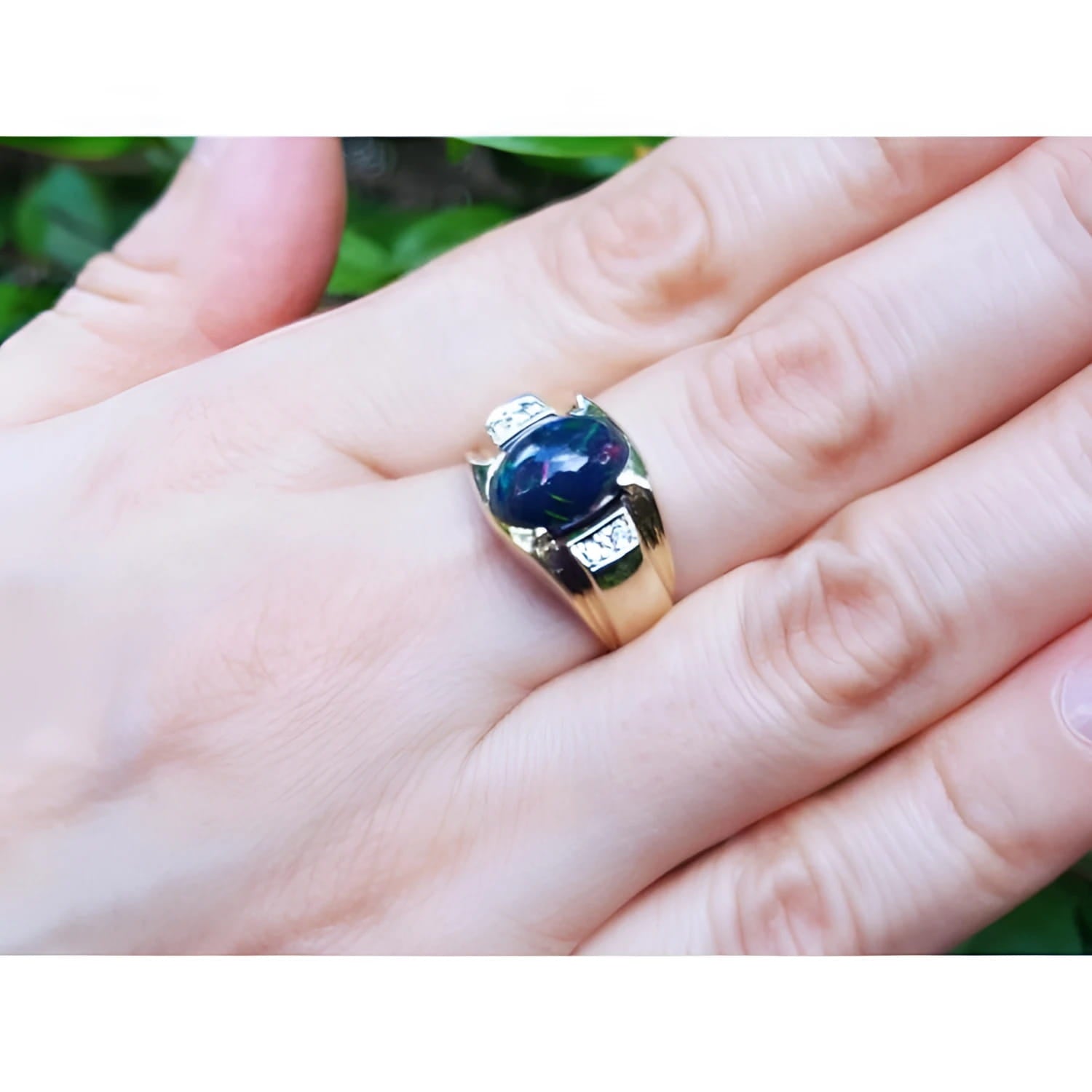 Men's 14K yellow gold ring with a striking oval Ethiopian black opal and small side diamonds.