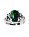 The topside view of a silver ring with a black Ethiopian opal on a white background