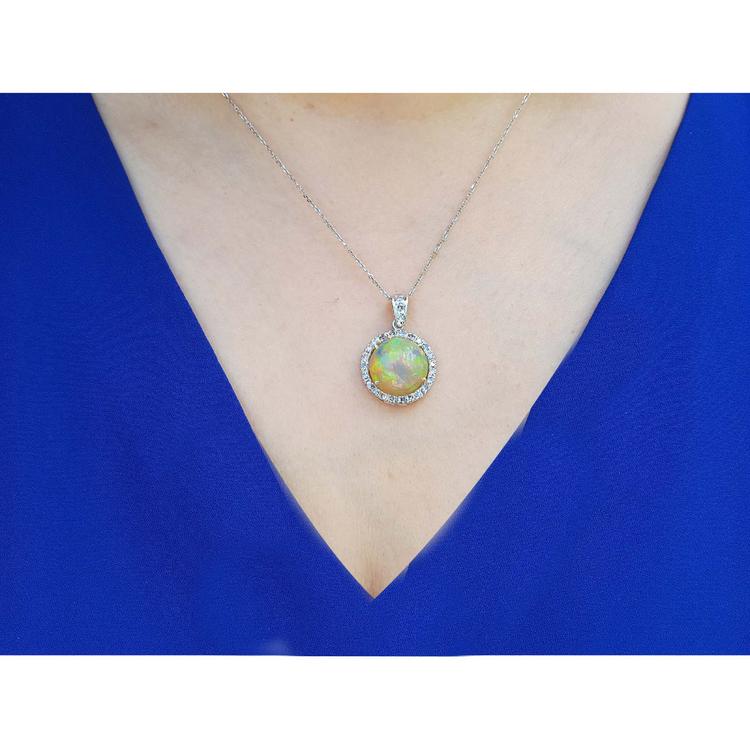 Ethiopian Welo opal and diamond pendant in 14K white gold, worn on a woman's neck.
