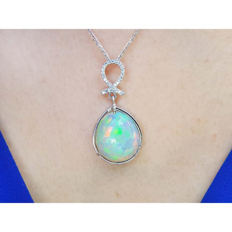 Ethiopian Welo opal and diamond pendant in 14K white gold, worn on a neck.