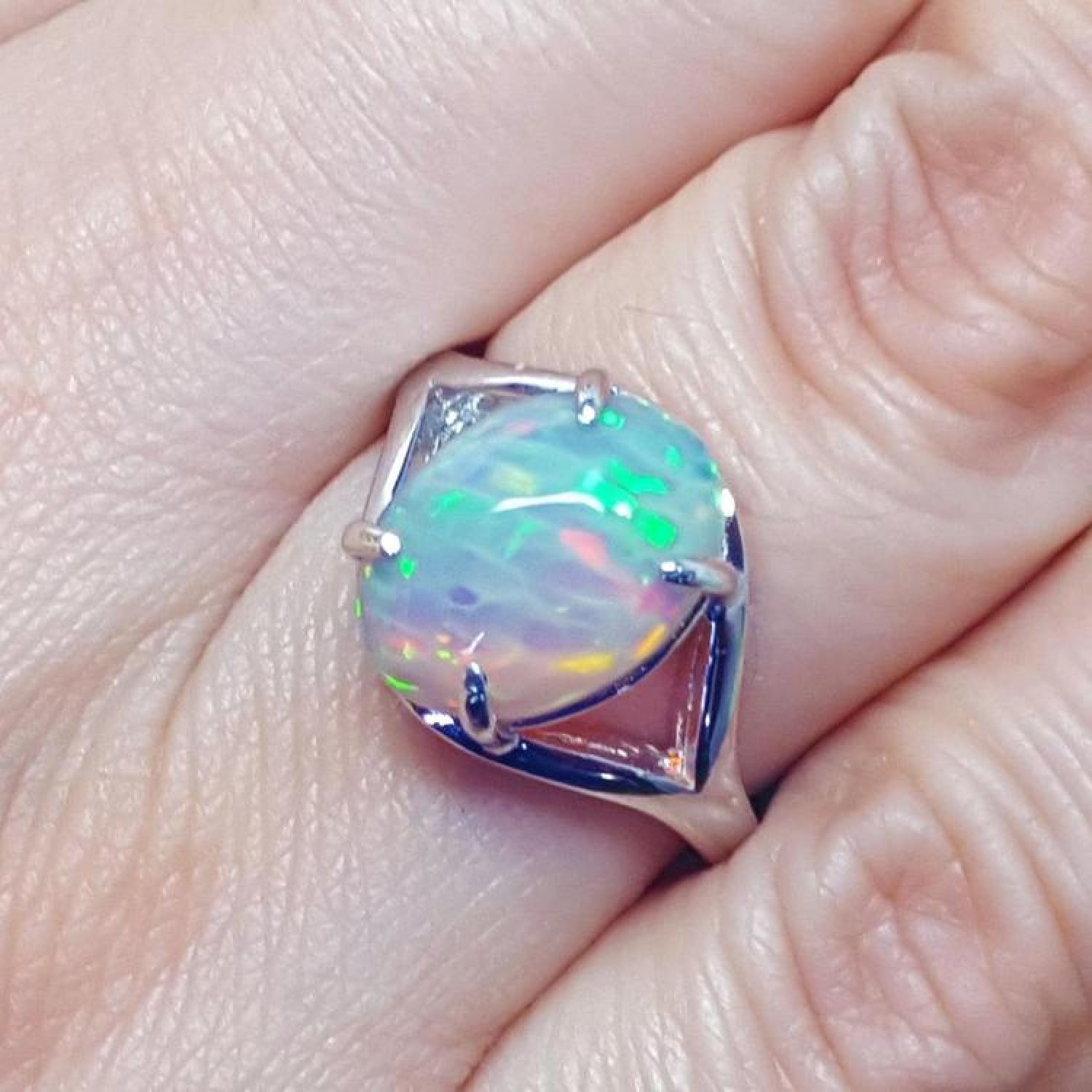 Ethiopian opal sterling silver ring with an oval cut, displaying vibrant red, orange, and green play of color.