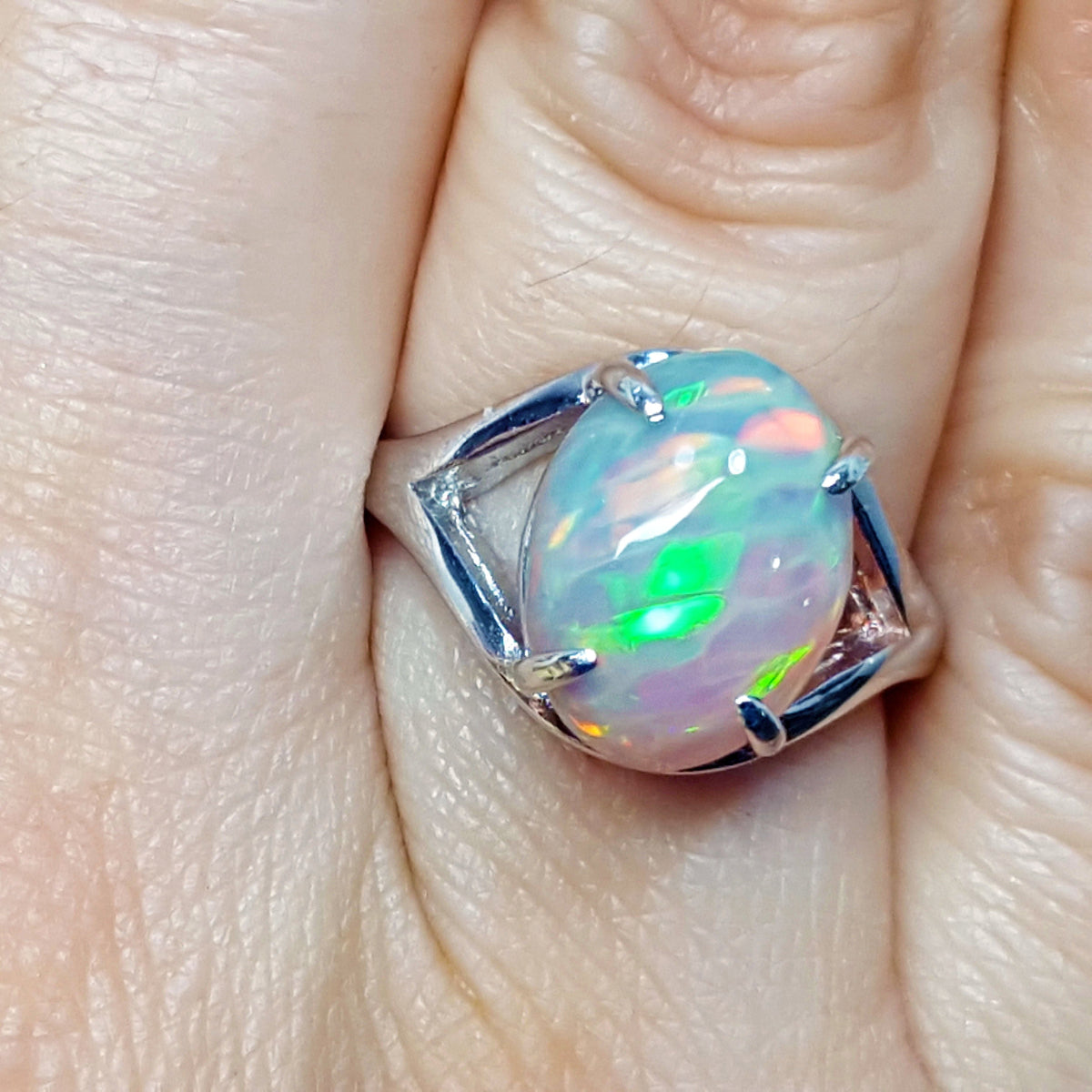 Opal ring with silver setting on a finger
