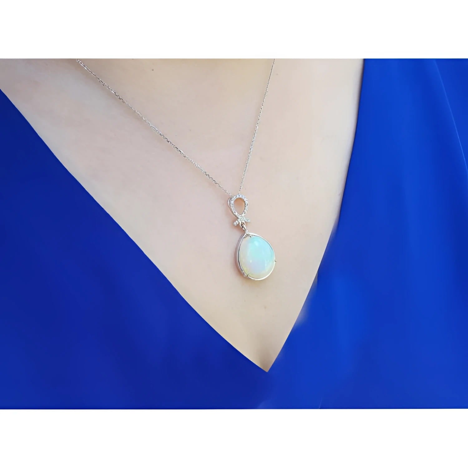 Ethiopian Welo opal and diamond pendant in 14K white gold on a woman's neck.