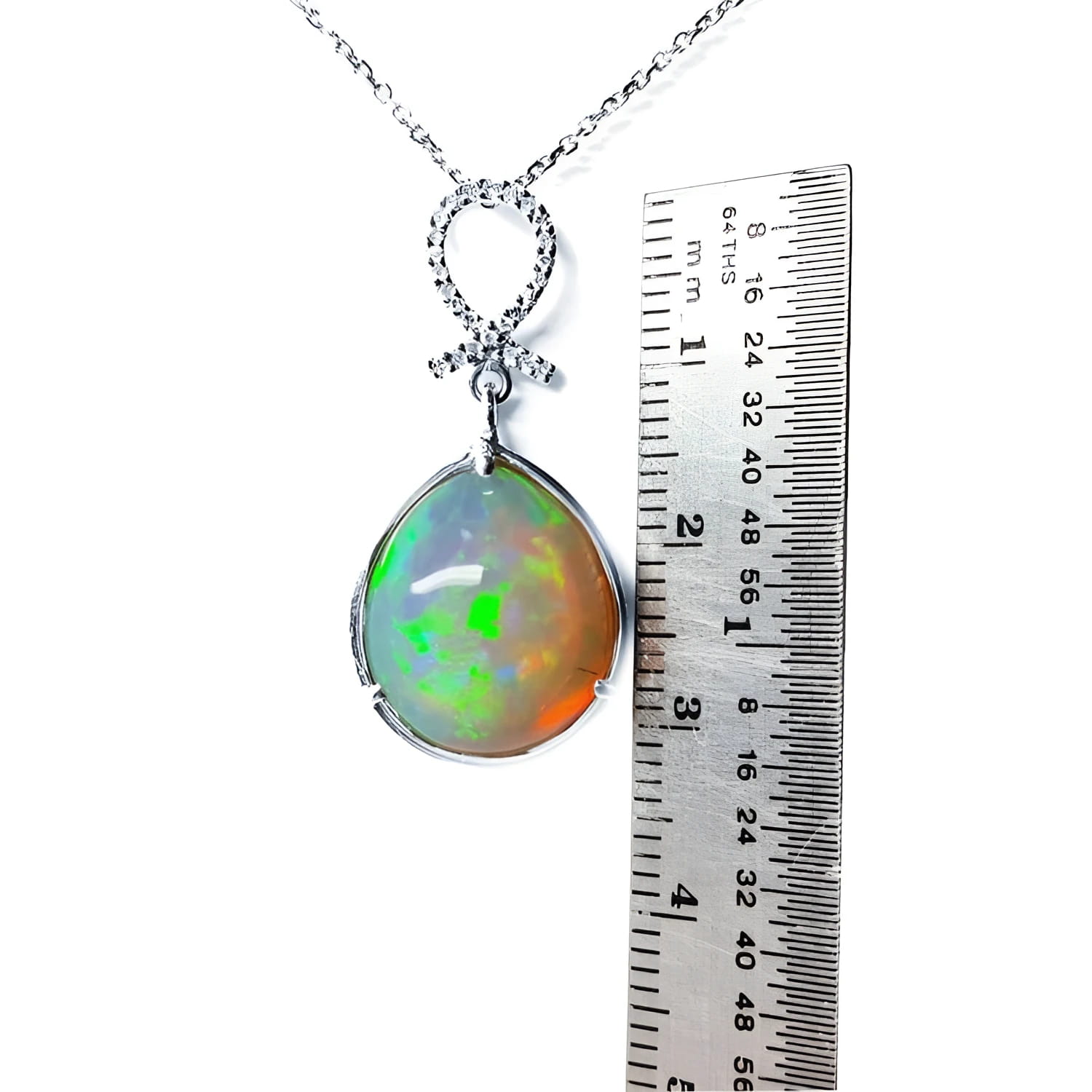 Ethiopian Welo opal and diamond pendant in 14K white gold, shown with a ruler for scale.