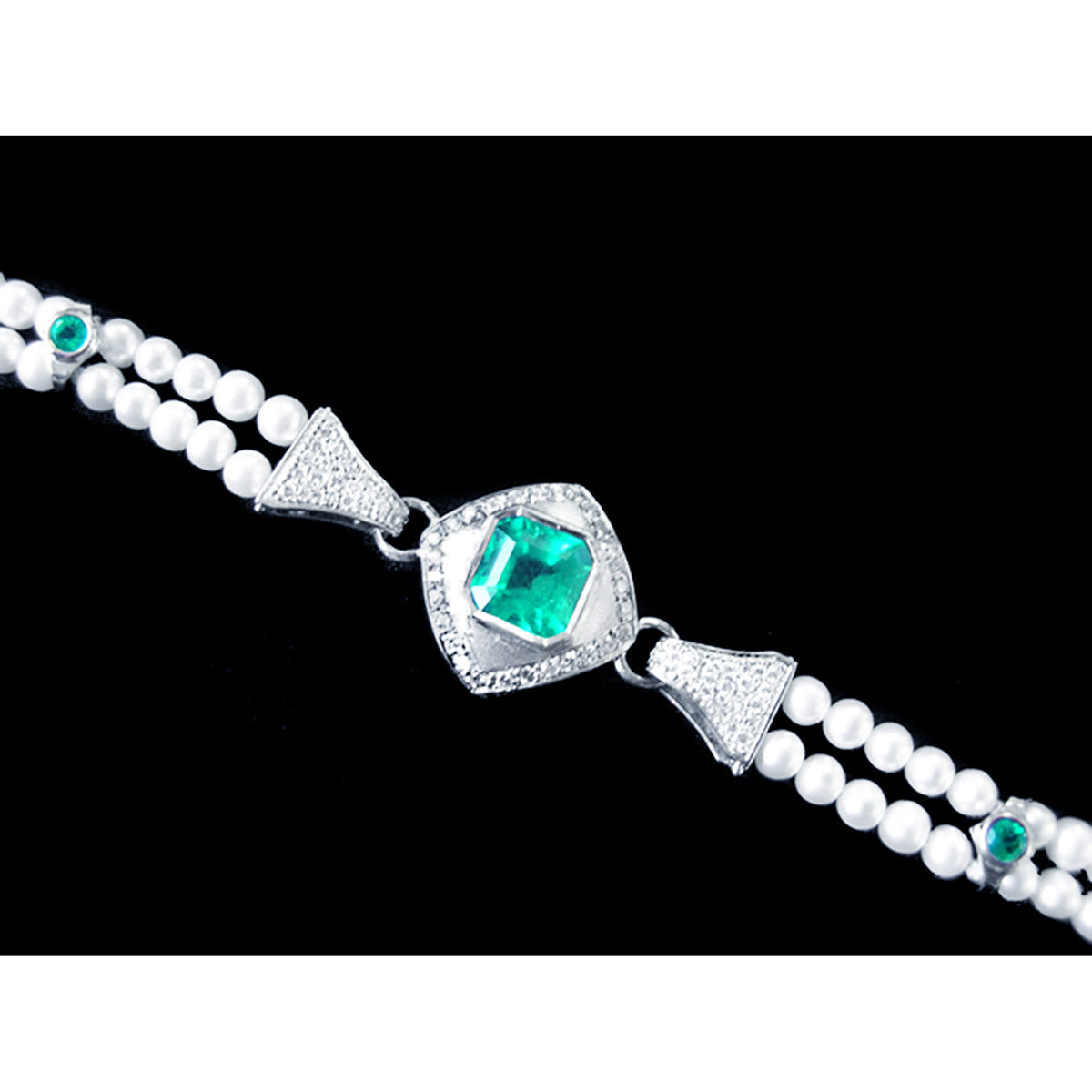 Pearl bracelet with a white gold and diamonds center piece and a square emerald on a black background.