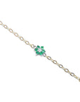 Gold bracelet with a green gemstone flower on a white background.