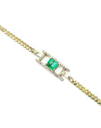 Gold bracelet with a centered colombian emerald on a topside far view.