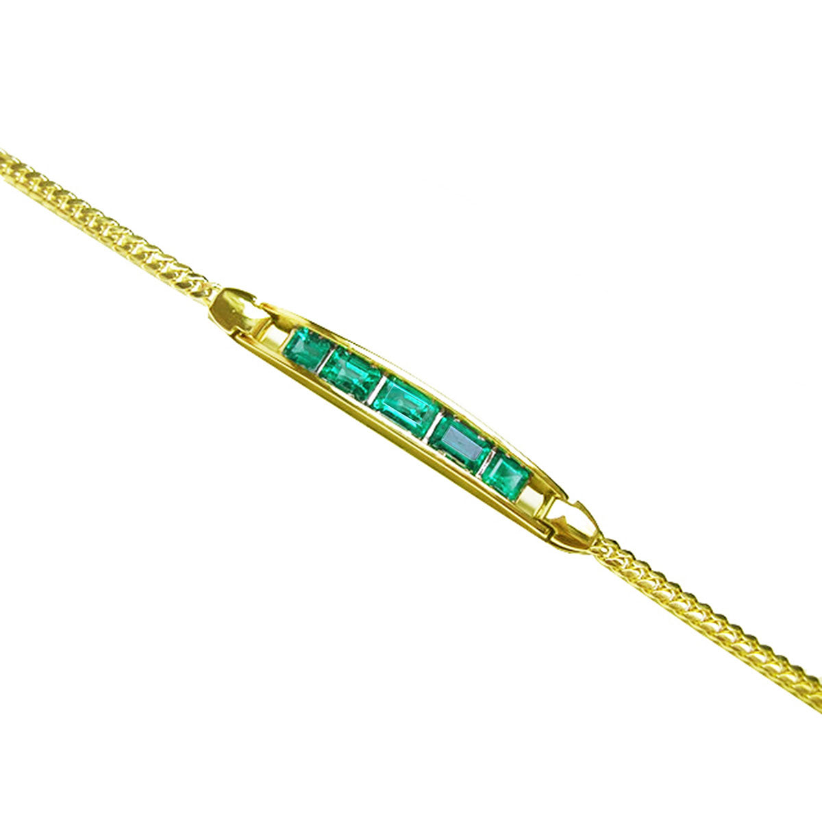 This far view of a gold bracelet with natural emeralds is on a white background.