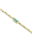 A yellow gold bracelet with a genuine emerald gemstone with diamonds accent on a white background