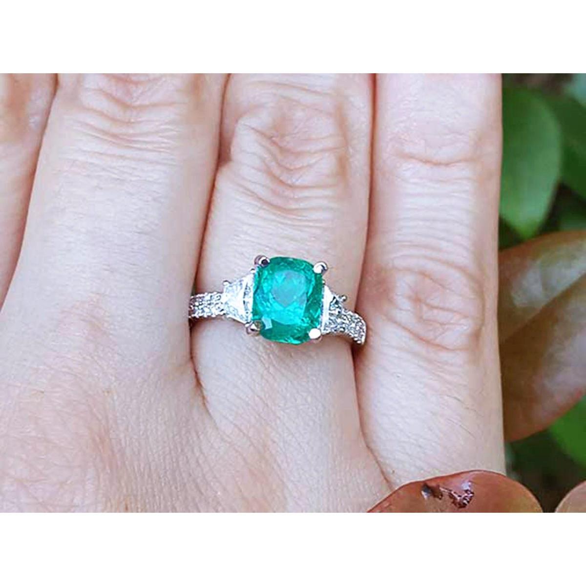 Cushion cut side trapezoid natural diamond ring for women on a finger with a blurred natural background,