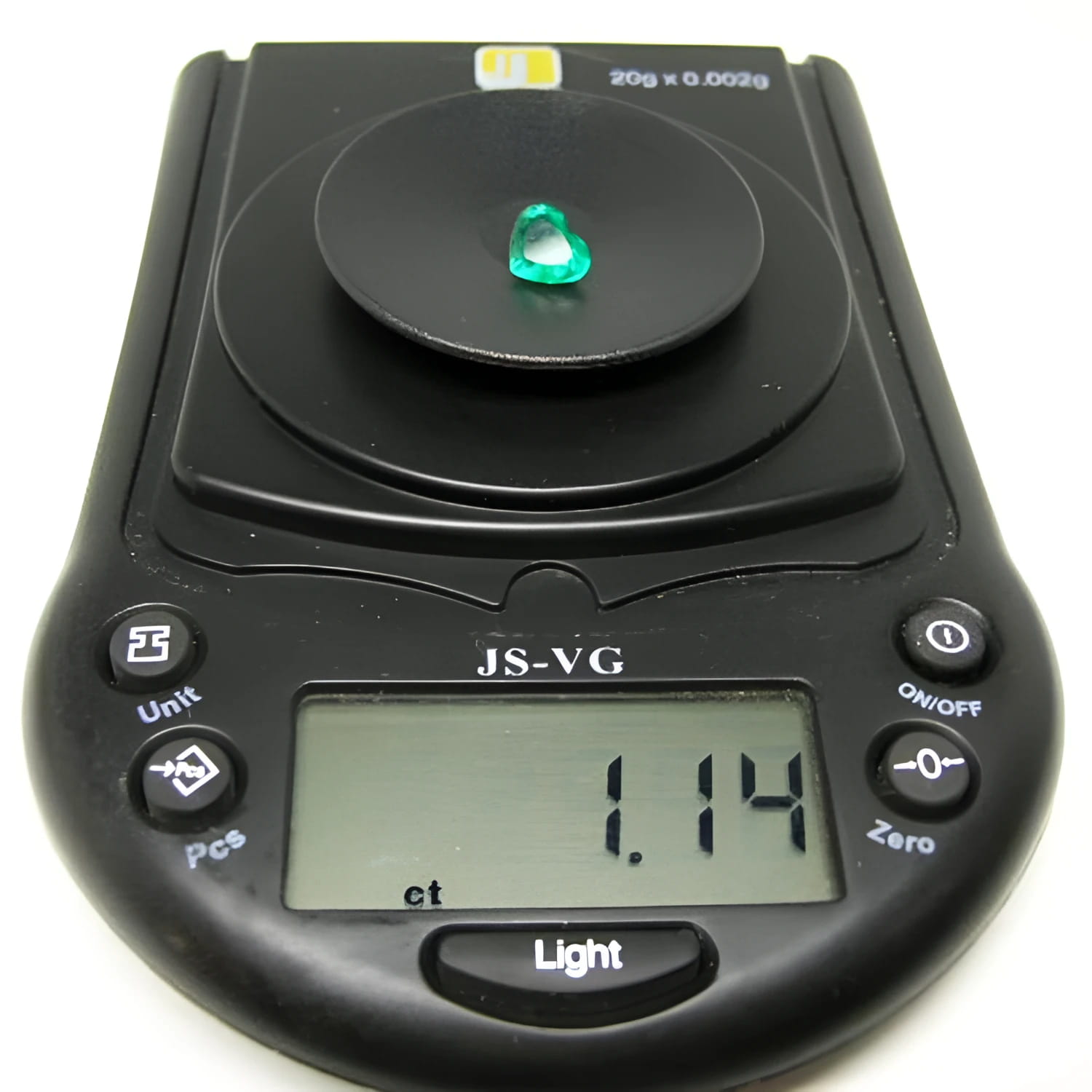 1.14 carat heart-cut Colombian emerald on a black digital jewelry scale.