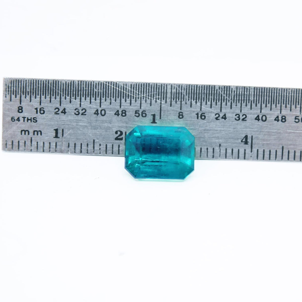 Fine quality loose Mizo mine Colombian emerald next to a ruler for measure size
