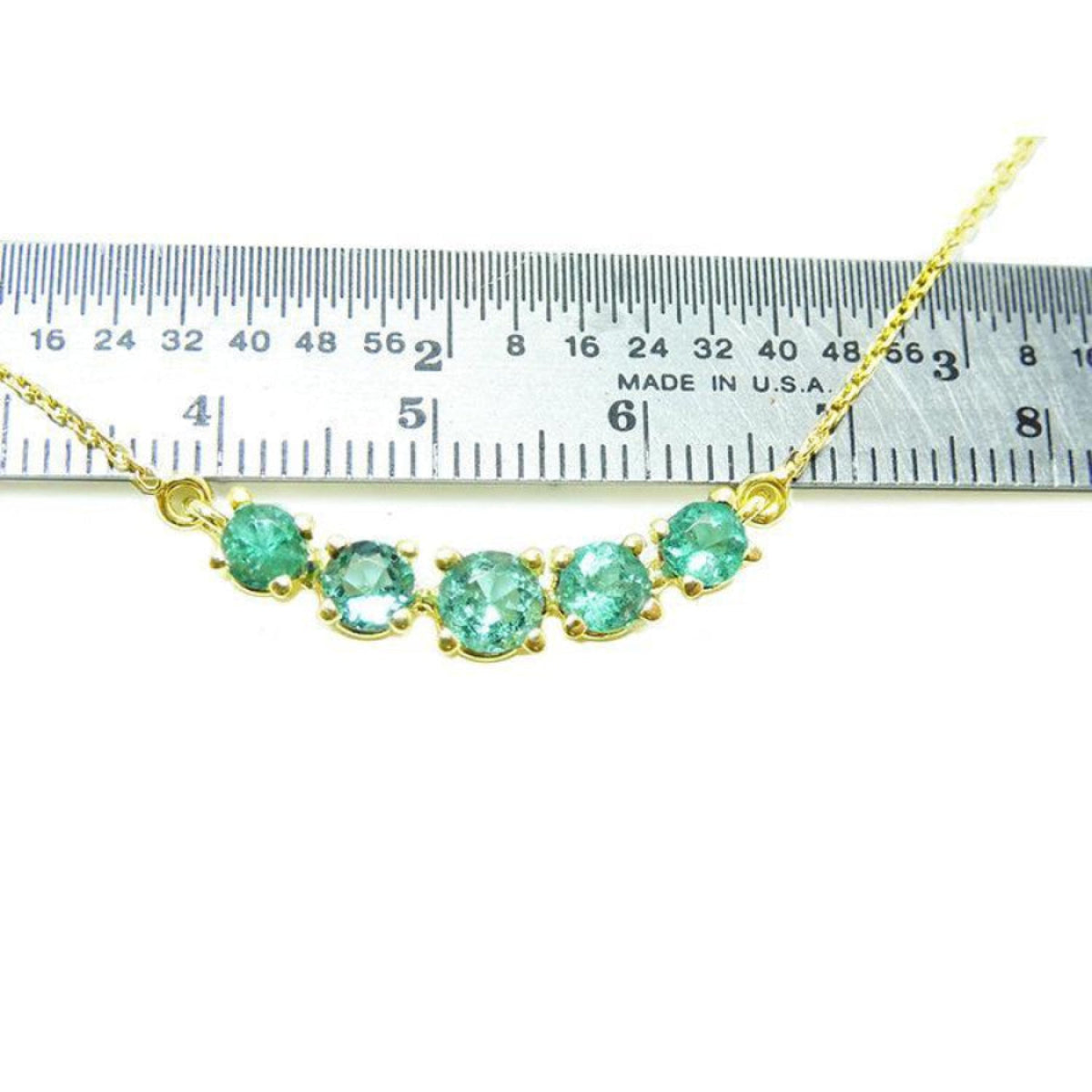 Green Fire Emerald Necklace with five sparkling round cut emeralds on a 14K gold chain, measured against a ruler.