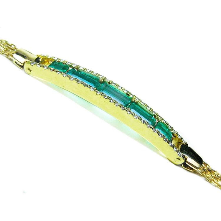 The side profile view of a gold bracelet with five natural emeralds on a white background.