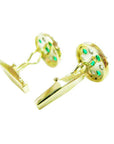 Gold cufflinks with colombian emeralds, downside profile view on a white background