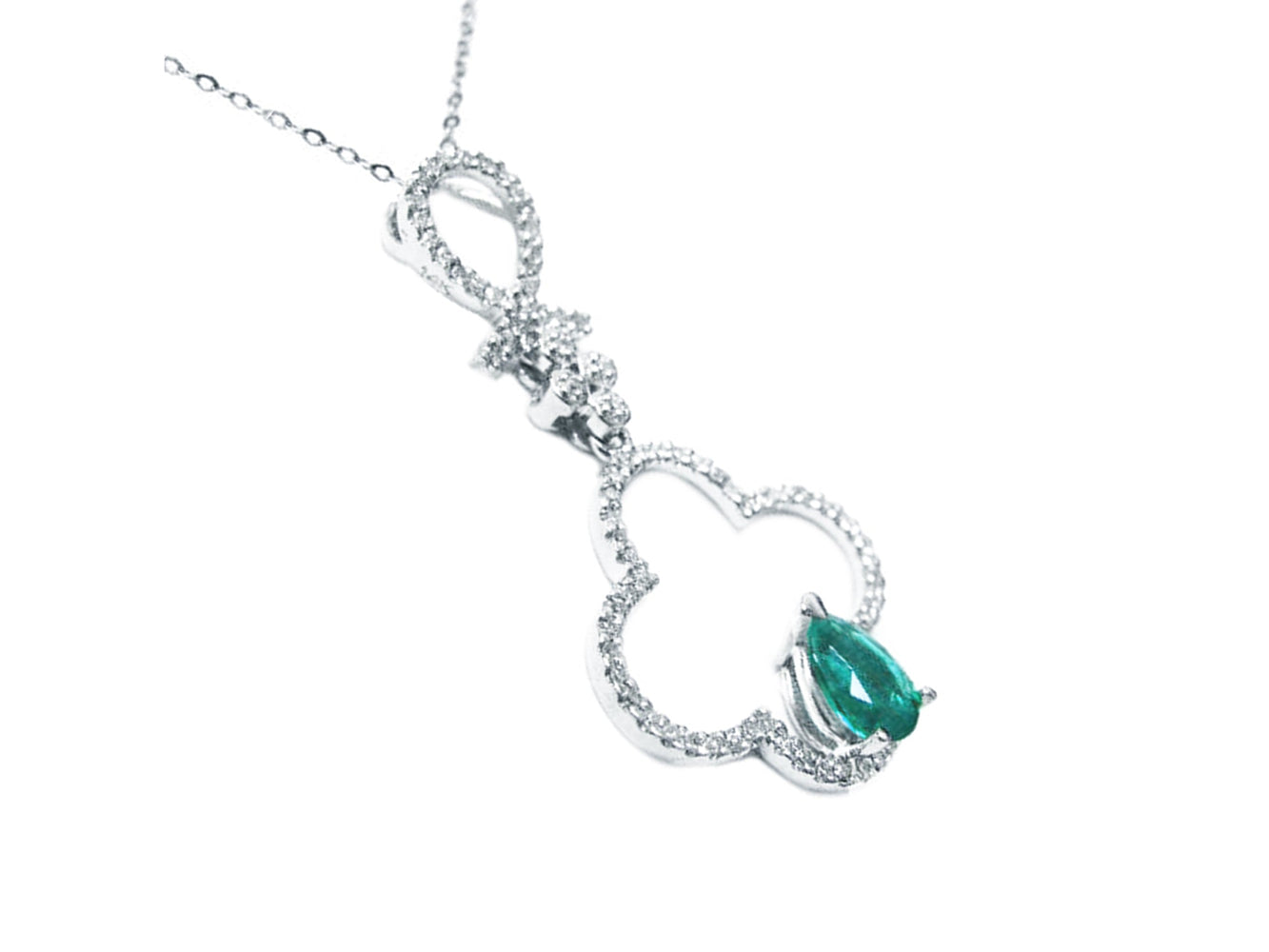 Diamond necklace four-leafe with a central emerald stone on a white background.