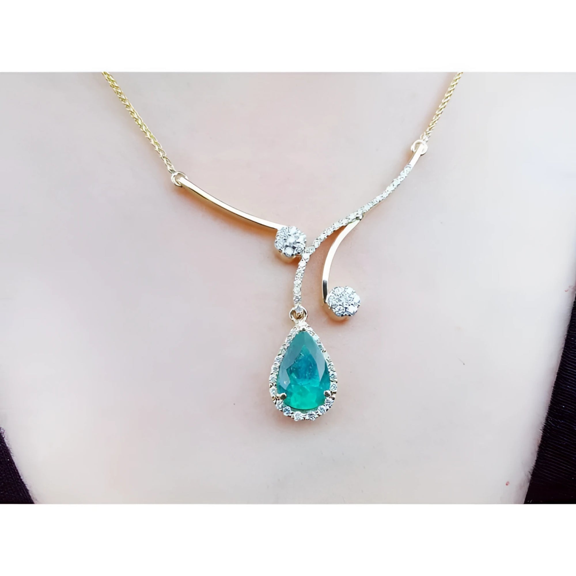18K yellow gold necklace with a pear-shaped Colombian emerald pendant and diamond clusters.
