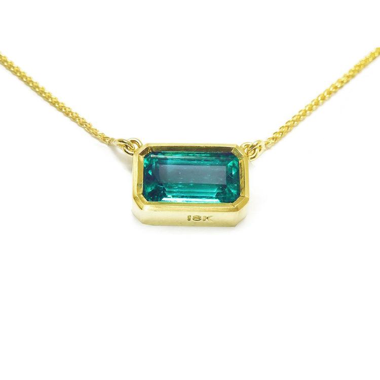 Emerald-cut emerald solitaire women's necklace east-west orientation handcrafted in 18k yellow gold