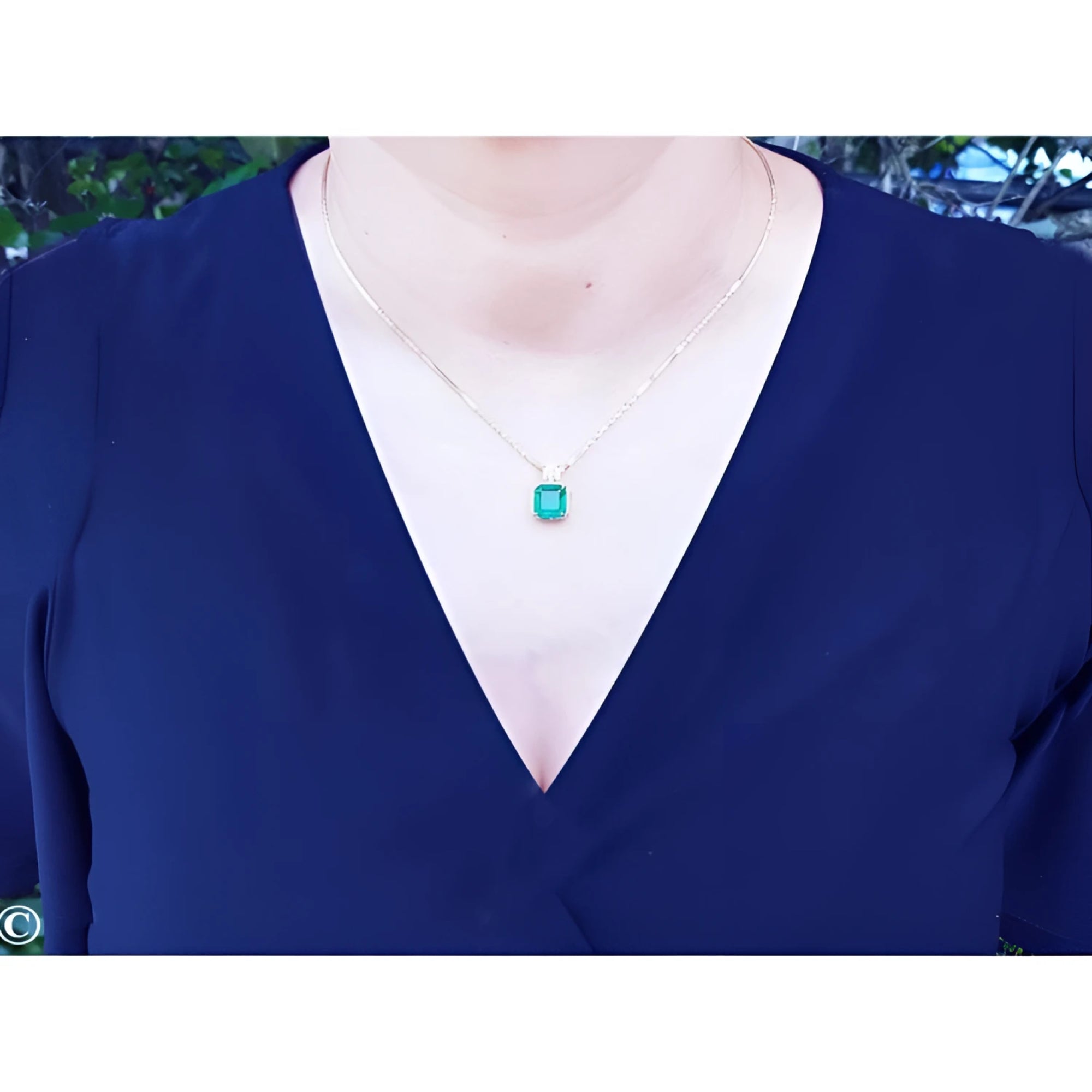 Asscher cut Colombian emerald necklace with a princess cut diamond on an 18K yellow gold chain.