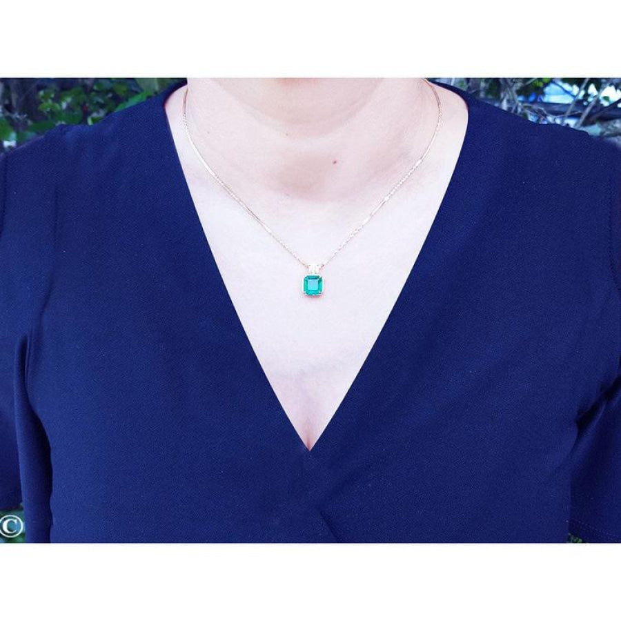 Asscher cut Colombian emerald necklace with a princess cut diamond on an 18K yellow gold chain.