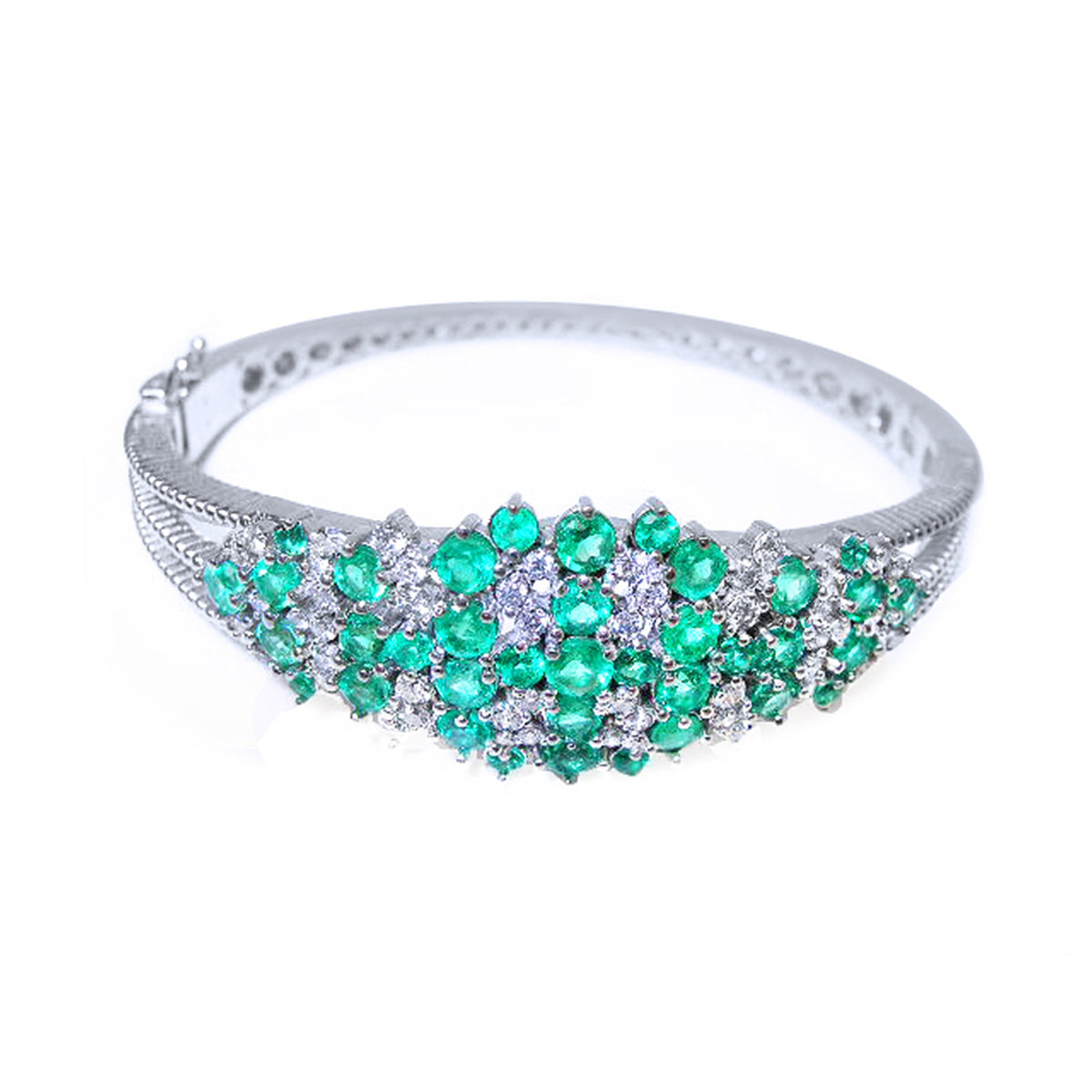 Jewelry with natural emerald and diamonds and a white gold band on a white background.