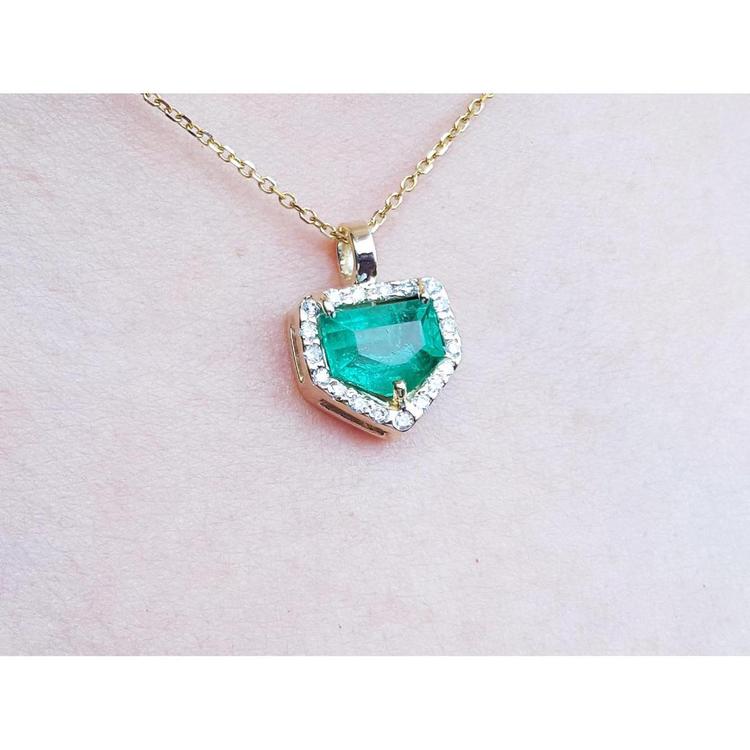 14K gold pendant with a vibrant green Colombian emerald and diamond halo.