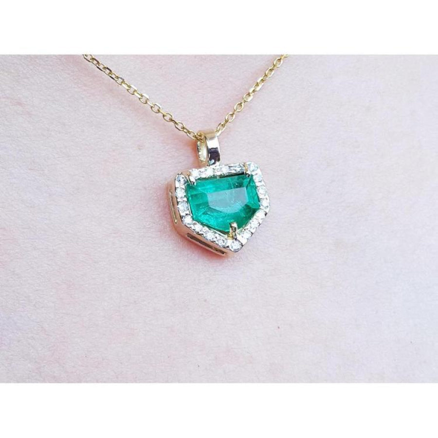 14K gold pendant with a vibrant green Colombian emerald and diamond halo.