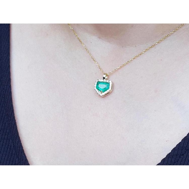 1.75 ct Colombian emerald pendant with diamond halo on a 14K gold chain.