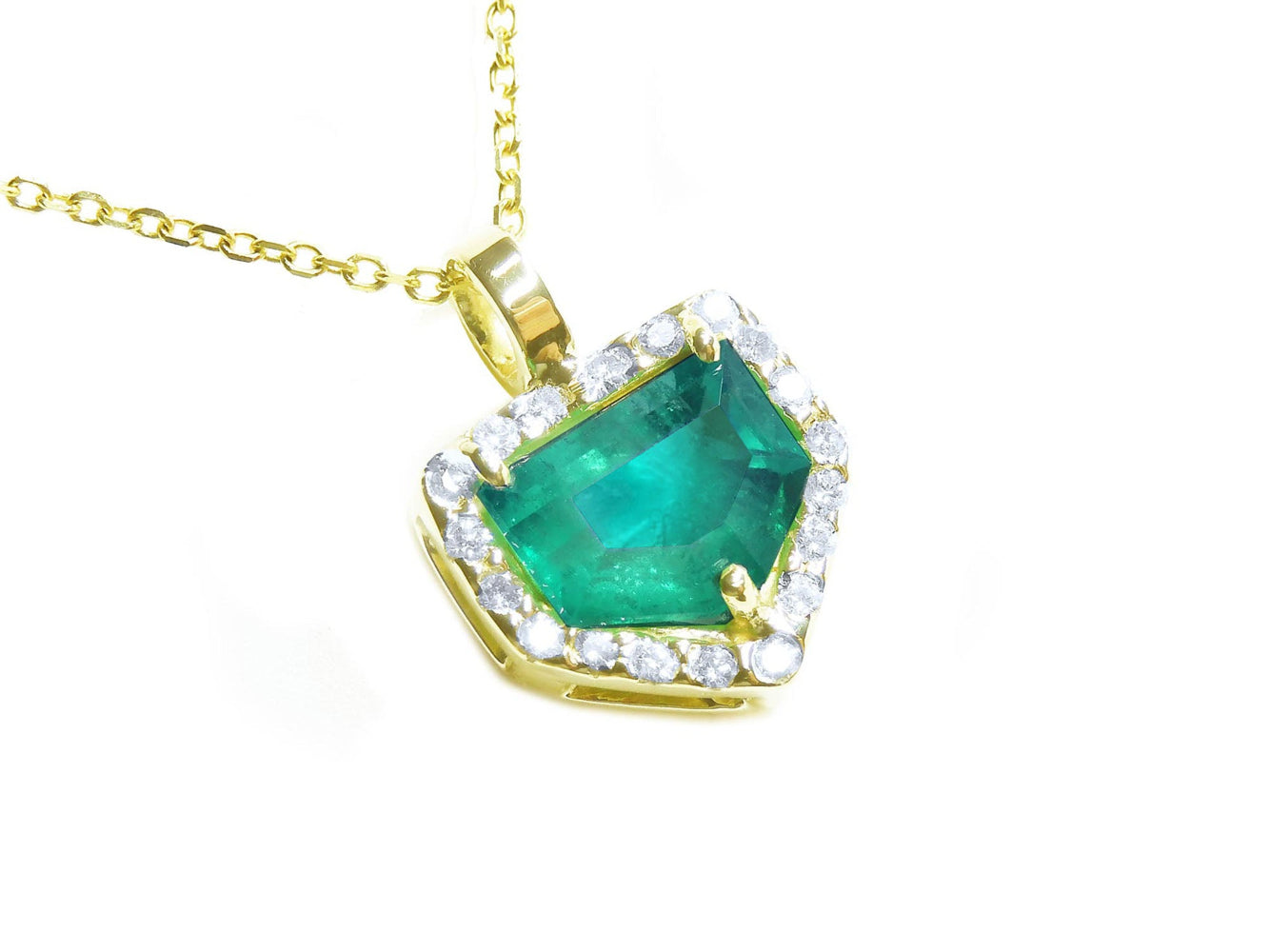 Yellow gold pendant with a natural emerald and diamond accents on a toside view.