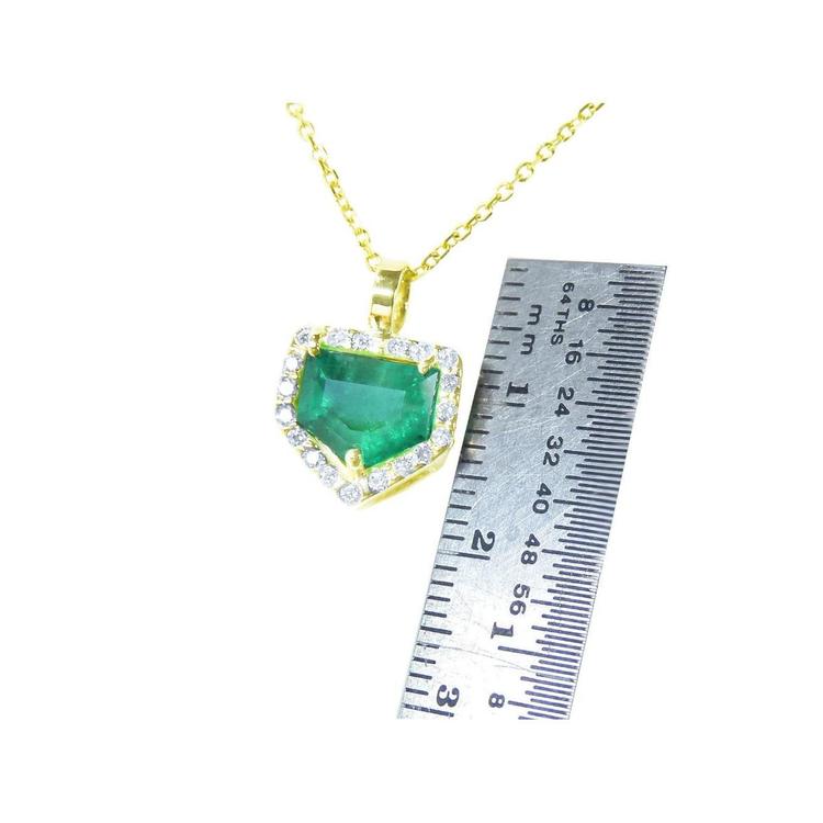 1.75 ct. Colombian emerald pendant with diamond halo on a 14K gold chain, shown with a ruler for scale.