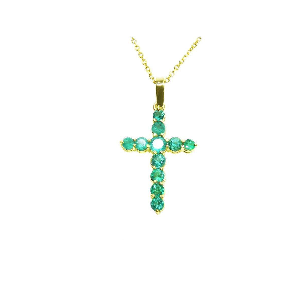 Yellow gold cross with round cut natural colombian emeralds showing its topside view.